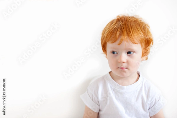 Obraz Pensive redhead boy on a white background