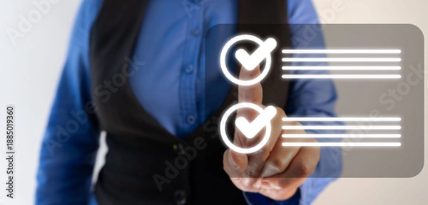 Obraz A business professional points to checkmarks on an interactive touchscreen background.