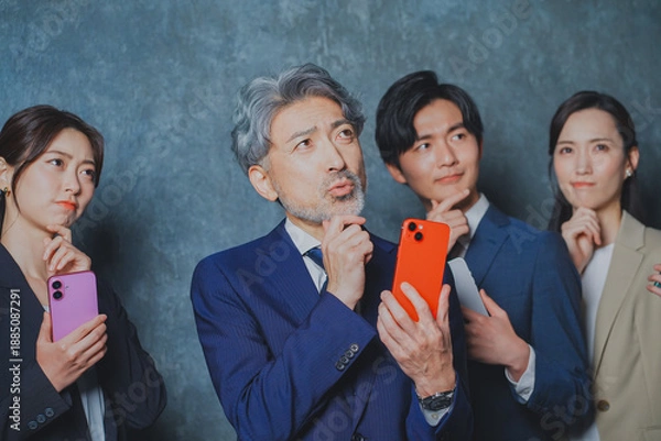 Fototapeta スマートフォンを手に持って悩むビジネスマン