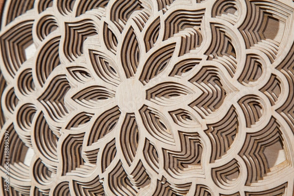 Fototapeta the layers of the mandala are cut from a tree by a laser