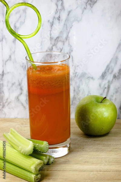 Obraz Fresh, healthy, homemade carrot juice in a glass with carrots, apple and celery stalks, Vegetable juice.