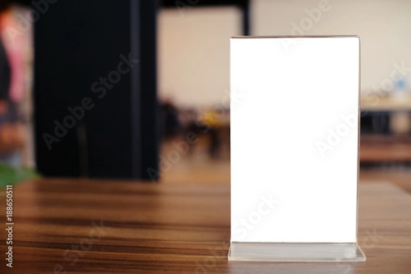 Fototapeta Mock up Menu frame standing on wood table in Bar restaurant cafe. space for text.
