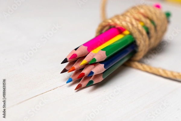 Obraz colored pencils tied with a string on a white table