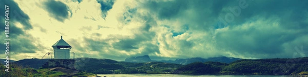 Obraz Lighthouse against dramatic cloudy sky during sunset