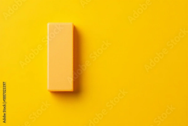 Fototapeta Yellow rectangular object on yellow background with shadow  simple still life composition