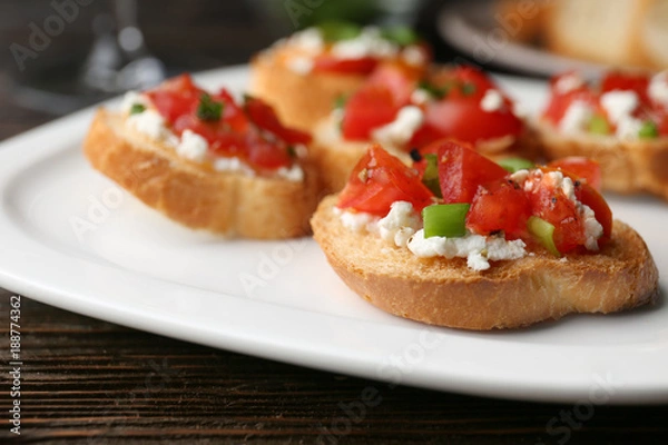 Obraz Tasty bruschettas with tomatoes on plate, closeup