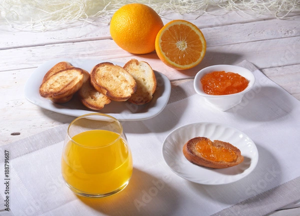 Obraz Morning Breakfast set with orange jam on bread toast and juice in glass.