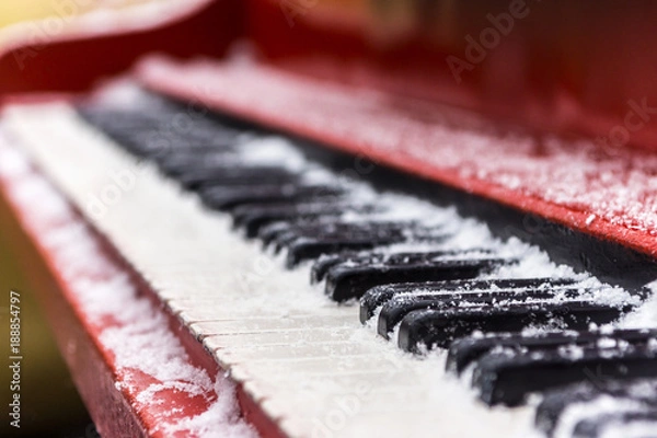 Fototapeta Ancient red piano, keys of which are covered with snow