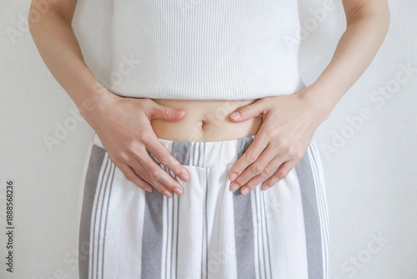 Fototapeta お腹を押さえる女性の腹部　ダイエット