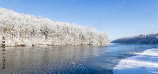 Obraz Snow-covered forest alongside a river