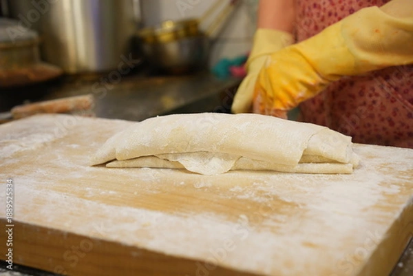 Fototapeta 나무 도마 위에서  쫄깃한 식감의 수제 칼국수 생면 반죽 과정