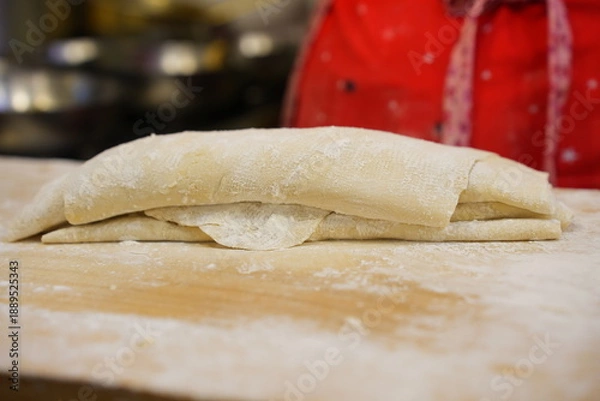 Fototapeta 나무 도마 위에서  쫄깃한 식감의 수제 칼국수 생면 반죽 과정