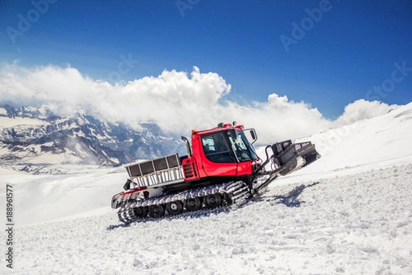 Fototapeta Russia, Terskol - July 29, 2017: Red ratrak on the slope of the Elbrus mountain. Every year dozens of snowcats prepare slopes for skiers