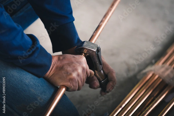 Fototapeta Industry system men worker cut joint with tool of copper pipe air conditioner
