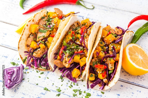 Fototapeta Meksykańskie tacos wieprzowe z warzywami i dynią. Tacos na drewnianym tle rustykalnym białym. Widok z góry.