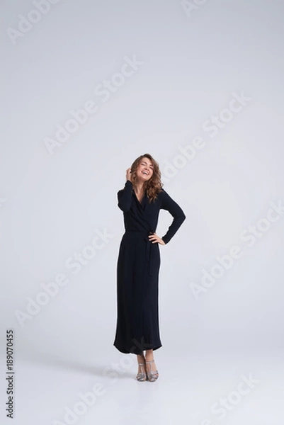 Fototapeta Candid trendy young model posing at camera in studio