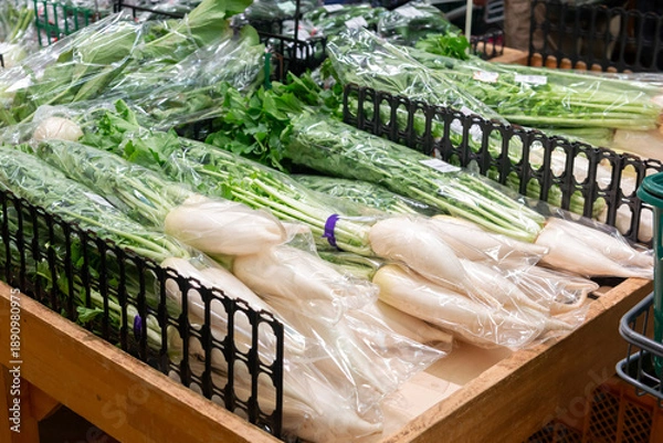Obraz 直売所に並ぶ袋詰めされた大根のクローズアップ