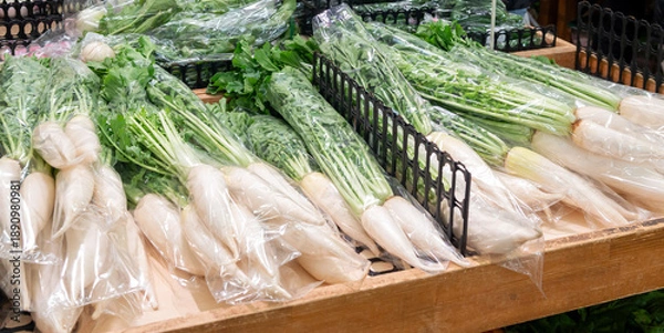 Obraz 直売所に並ぶ袋詰めされた大根のクローズアップ
