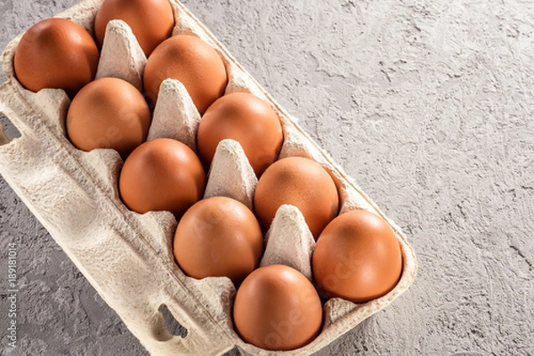 Fototapeta Farm raw fresh egg in pack on gray table scrambled eggs omelet fried egg
