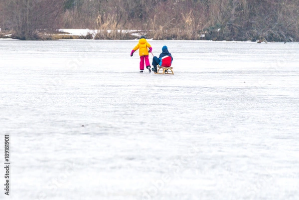 Fototapeta Kinder mit Rodel am Eis