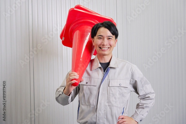 Fototapeta 三角コーンを持つ作業員　倉庫　ポートレート　カメラ目線