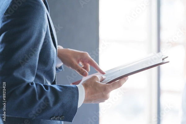 Fototapeta 紙資料を指差しチェックする男性ビジネスマン