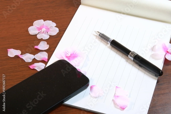 Obraz 日本の春のイメージ：机の上に置かれた便箋、万年筆、スマホ、桜の花びら(横長)
