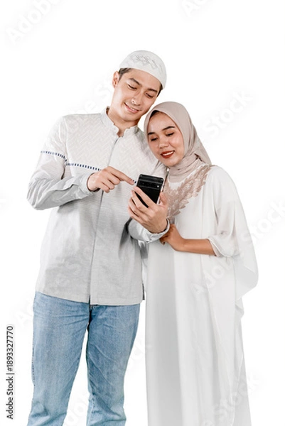 Obraz Smiling Muslim Couple Using Smartphone Together on White Background