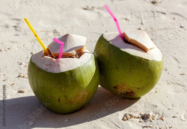 Obraz Two green coconuts with straws in them