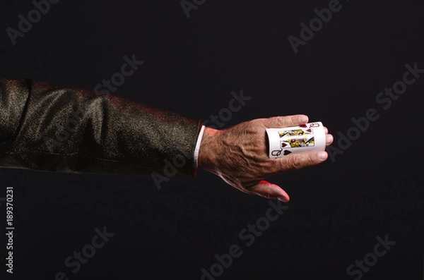 Fototapeta Magician shows trick with playing cards. Manipulation with props. Sleight of hand.