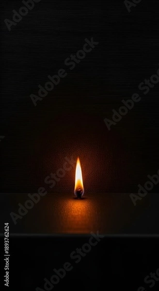 Obraz Single candle flame in darkness.
