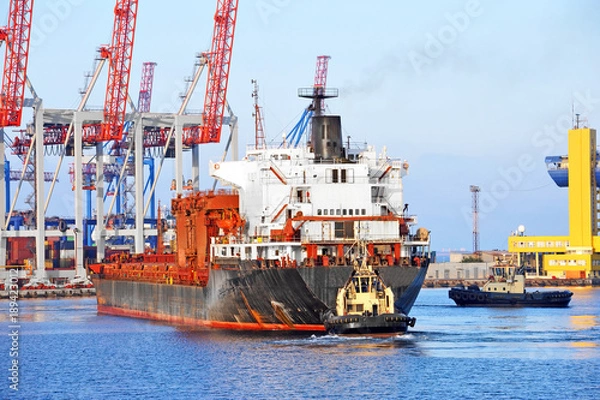 Fototapeta Tugboat assisting bulk cargo ship