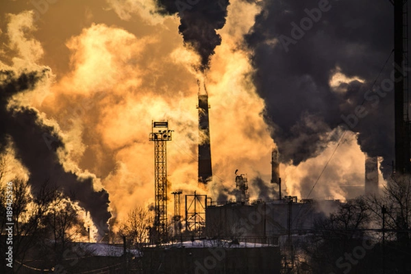 Obraz the chimneys of a refinery with smoke and steam with the pinkk sunset on the background