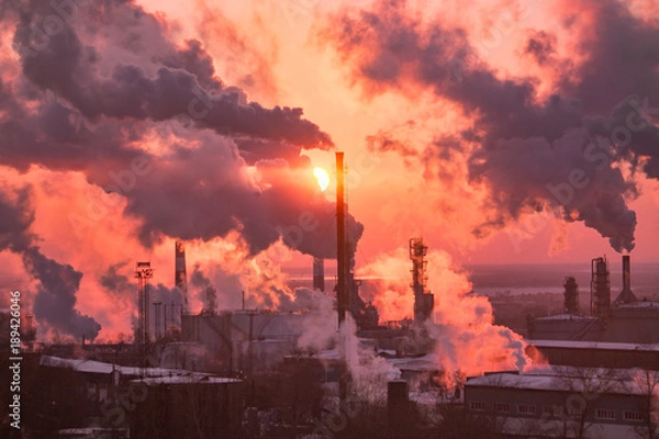 Obraz the chimneys of a refinery with smoke and steam with the pinkk sunset on the background