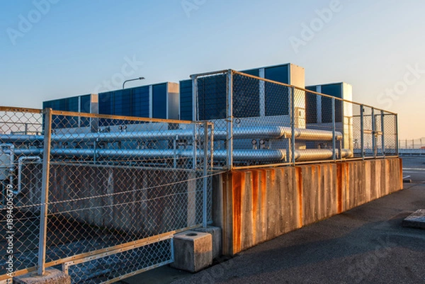 Obraz フェンス越しに見る建物の空調インフラと冷却システム