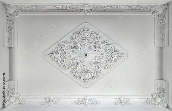 Fototapeta Decorative item made of white plaster on ceiling. Relief stucco interior