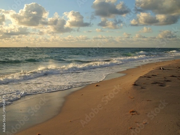 Fototapeta Coastal Calm. Gentle morning light, sculpted ledge from gentle surf, and smooth sand on waters edge with light reflection.