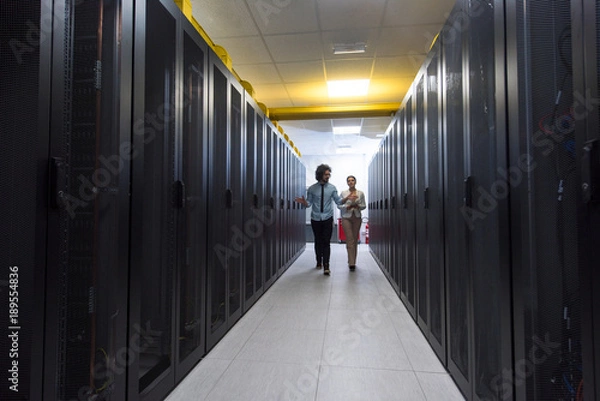 Obraz engineer showing working data center server room to female chief
