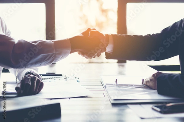 Fototapeta business partners handshaking after business success negotiation at meeting room.