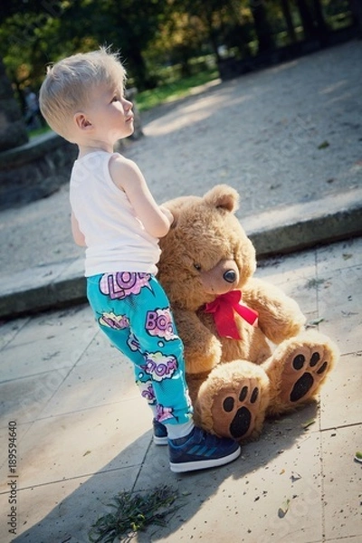 Obraz Junge steht mit Plüschtier