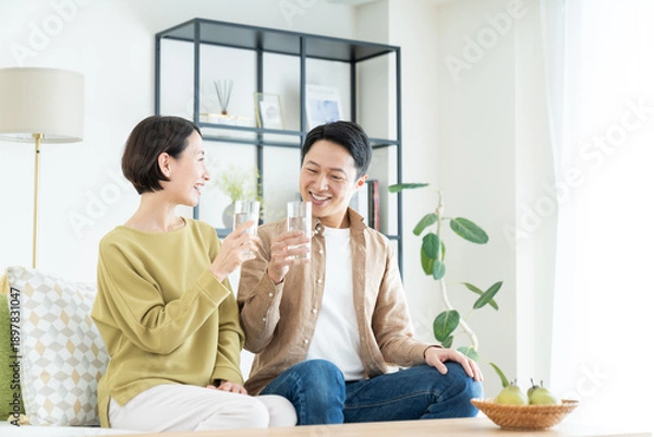 Obraz リビングでミネラルウォーターを飲むミドルの夫婦