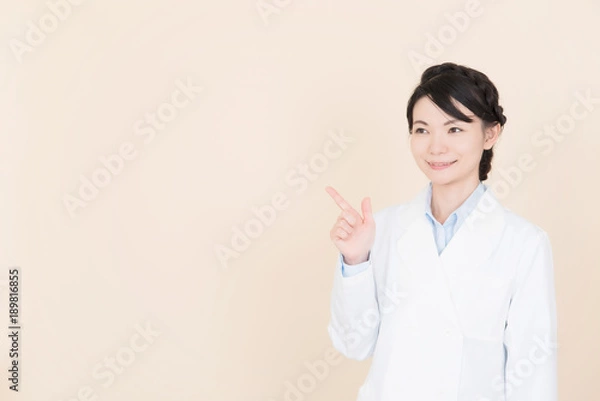 Fototapeta 余白を指差す白衣の女性