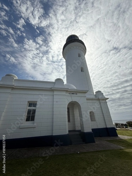 Obraz Historic White Lighthouse Against Dramatic Sky