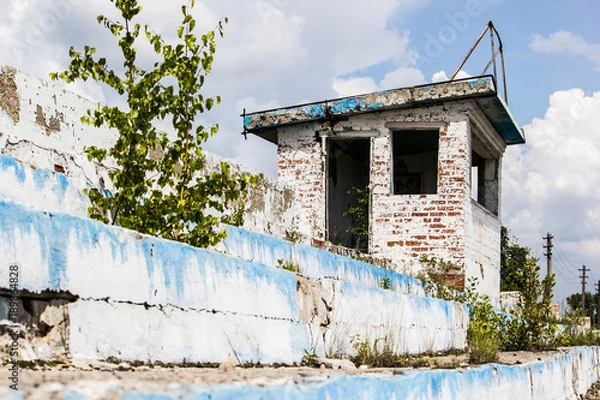 Fototapeta The old destroyed building with no Windows and blue sky