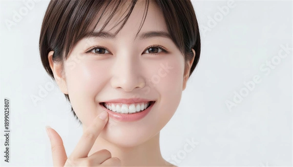 Obraz 綺麗な白い歯を指差して微笑むショートヘアの日本人女性