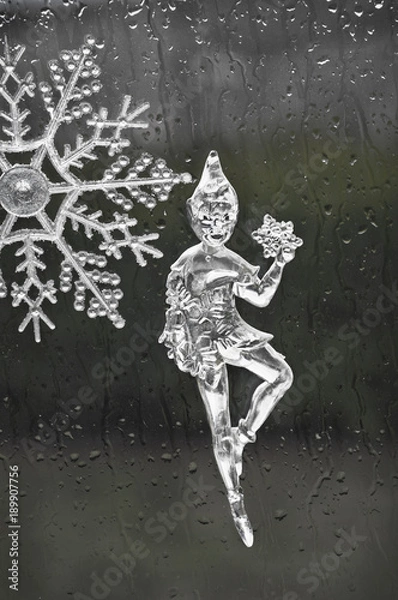 Fototapeta Elf fairy holding a snowflake made out of ice/Elf Christmas ornament figurine in ice holding a snowflake