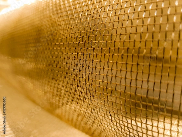 Obraz Gold mesh net with focus and shallow depto fo field, gold bokeh net pattern