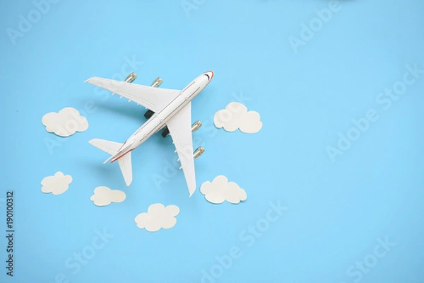 Fototapeta Płaski projekt koncepcji podróży z samolotem i chmurą na niebieskim tle z miejsca na kopię.