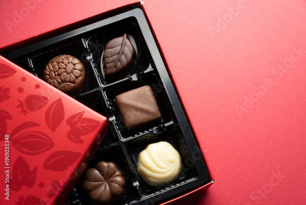Obraz Luxury assorted chocolates with copy space on red surface
