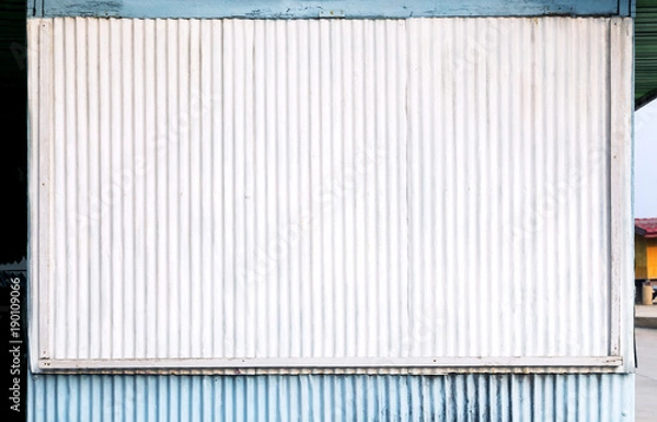 Fototapeta Corrugated zinc surface white and blue of the house is a roadside shop for the background and texture. With copy space for text.